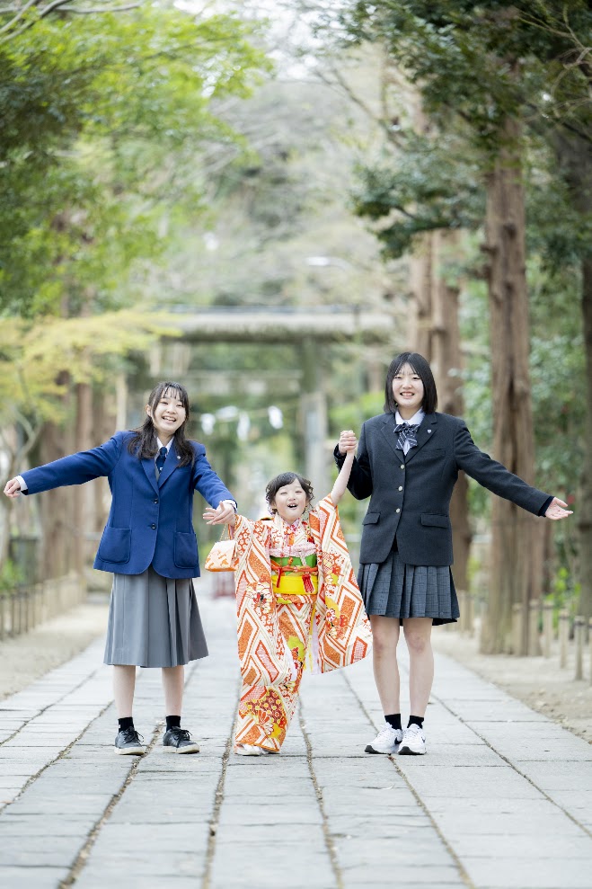 七五三の女の子ときょうだいで神社の参道にて
