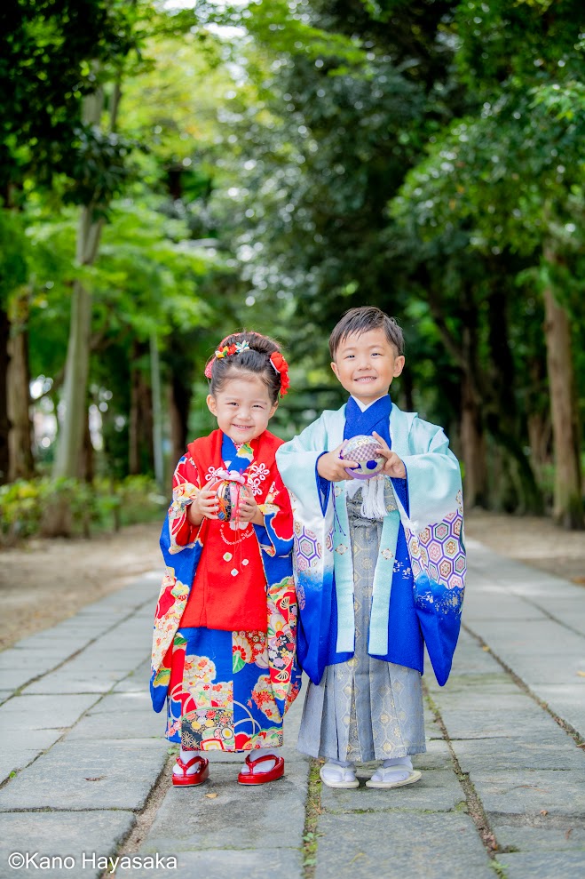 神社の参道で寄り添う七五三の姉弟