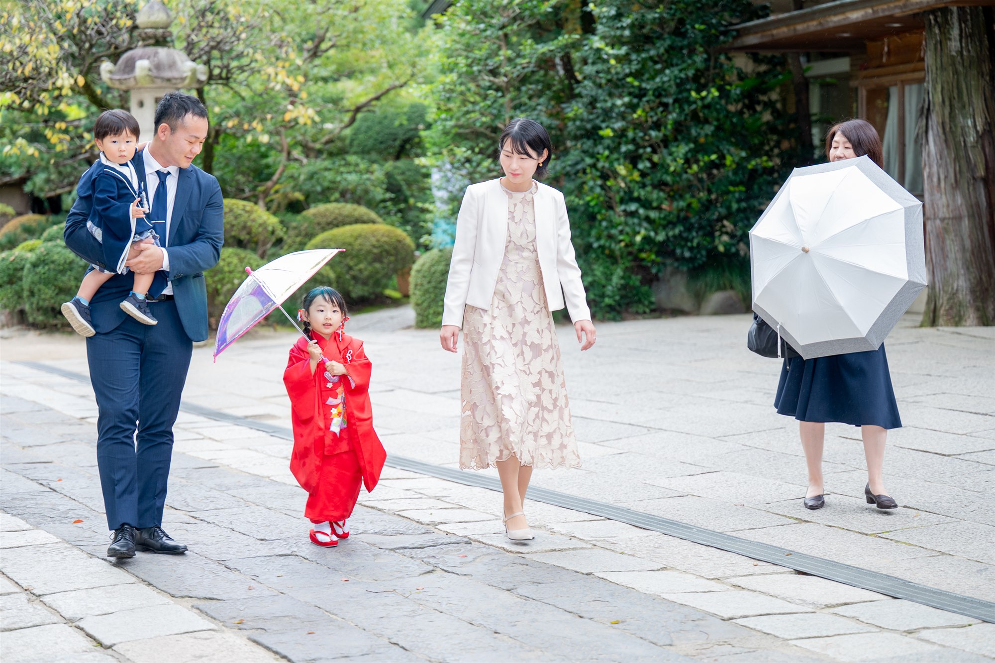 久伊豆神社の参道を傘をさして歩く七五三のご家族