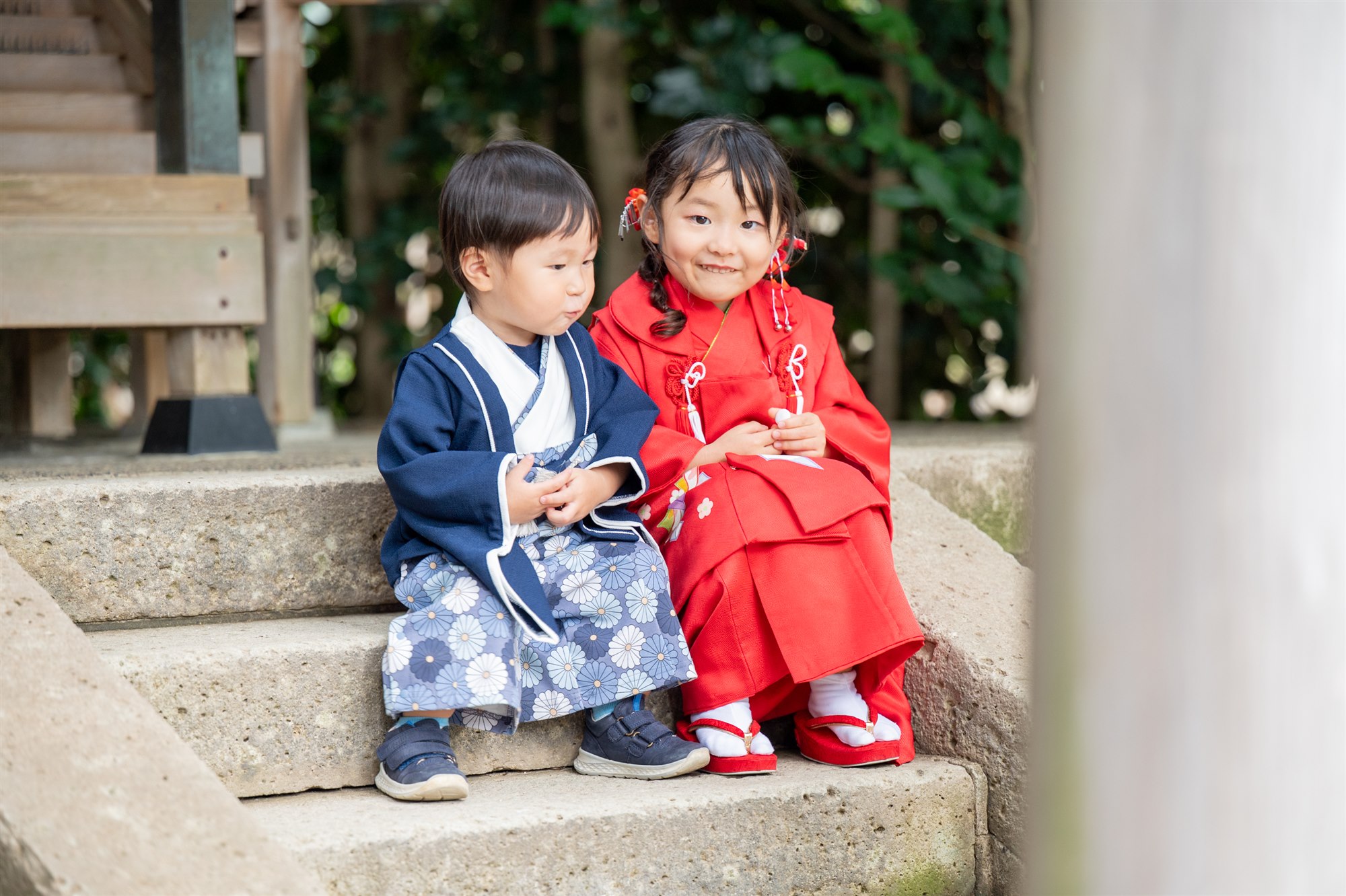 久伊豆神社の石段に並んで座る七五三の姉弟