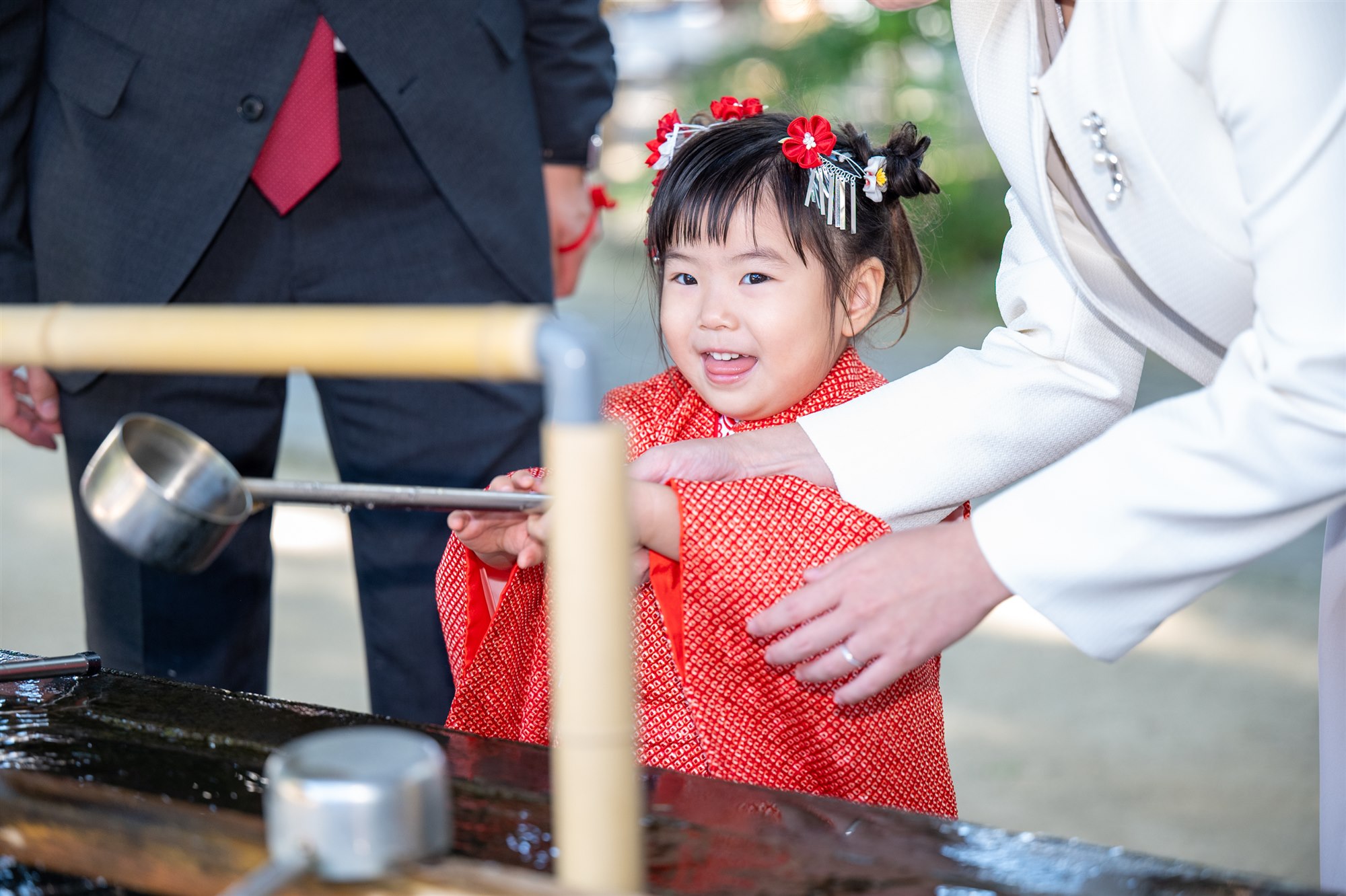 手水舎で柄杓を持つ七五三の女の子