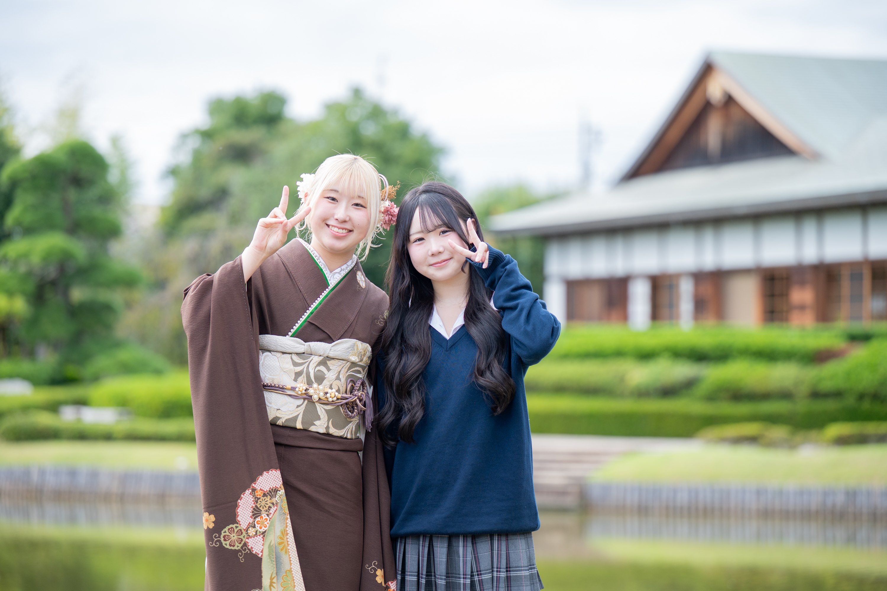 花田苑で、成人式の振袖姿でピースをして寄り添う姉妹