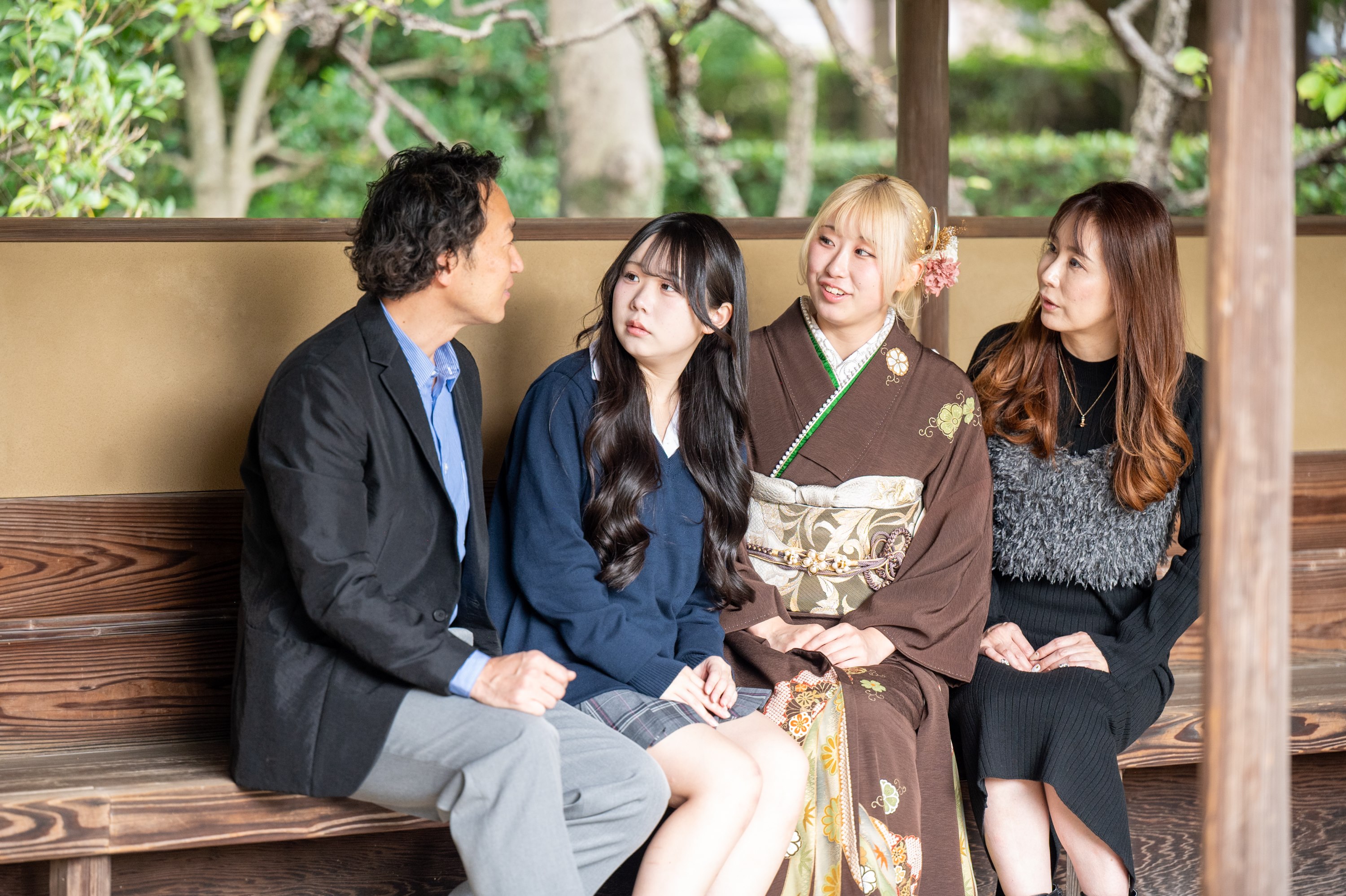 花田苑の東屋で顔を見合わせて笑う、成人式のご家族