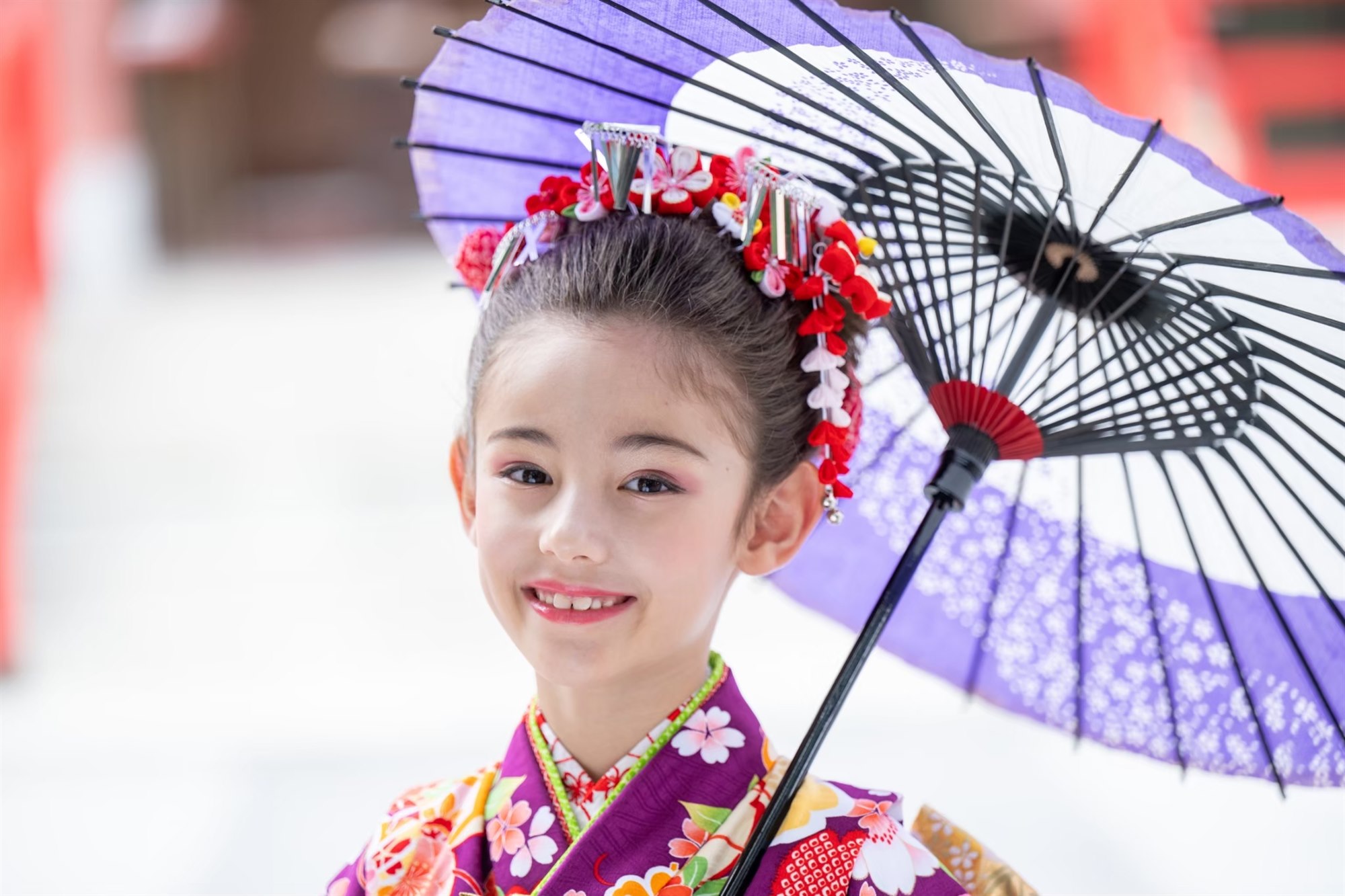 和傘をさして微笑む7歳の七五三の女の子